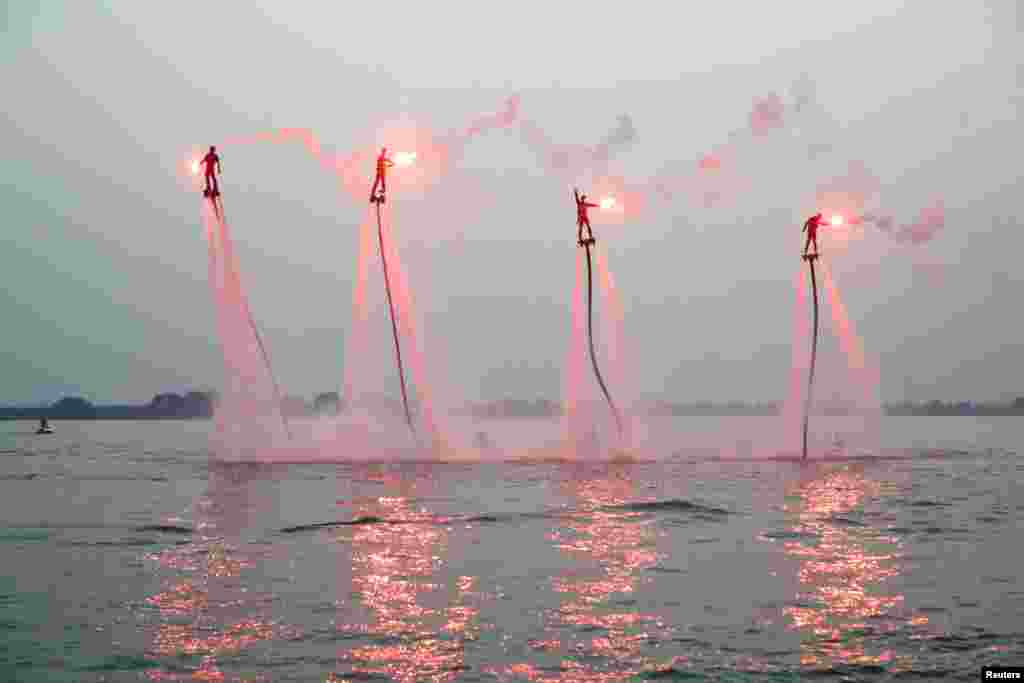 People riding on water-powered jet-boards perform in Yixing, Jiangsu province, China.