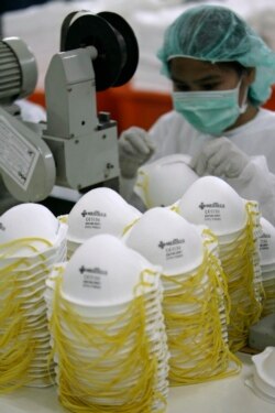 Seorang pekerja membuat masker N95 di dalam gudang Medtecs di Provinsi Bataan, utara Manila 30 April 2009. (Foto: REUTERS/Romeo Ranoco)