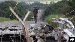 An Ukrainian government army soldier approaches to a damaged bridge near the village of Debaltseve, Donetsk region, eastern Ukraine, July 31, 2014. 