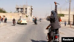 Celebración en las calles de la ciudad de Tabqa, en Siria, luego de ser tomada por militantes del Estado islámico.