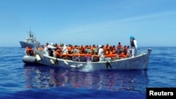 Migrants sit in their boat during a rescue operation by the Italian navy off the coast of Sicily in this handout picture from the Italian Marina Militare, released May 6, 2016. Italy's coast guard rescued about 1,000 people off the country's southern tip Thursday.