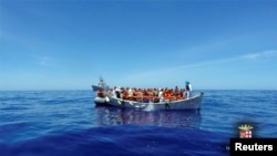 Migran duduk di perahu mereka selama operasi penyelamatan oleh kapal AL Italia Grecale. 
