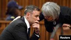 FILE - Former Paralympian Oscar Pistorius is comforted by an unidentified woman before his sentencing for the murder of Reeva Steenkamp at the Pretoria High Court, South Africa, June 13, 2016. 