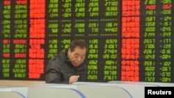 An investor looks at a computer screen showing stock information at a brokerage house in Fuyang, Anhui province, Jan. 28, 2016. 