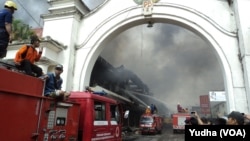 Petugas pemadam kebakaran berupaya memadamkan si jago merah yang melalap Pasar Klewer Solo, 28 Desember 2014 (Foto: VOA/Yudha)