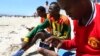 FILE - A Somali man browses the internet on his mobile phone at a beach in Somalia's capital Mogadishu, January 10, 2014.