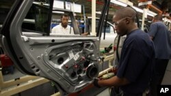 In this Feb 1, 2008 file photo Hyundai Motor Company employees work on vehicles at the Montgomery, Ala. plant.