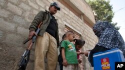 A Pakistani health worker marks the finger of a child after giving her a polio vaccine in Karachi, Pakistan, Monday, Feb. 15, 2016. 