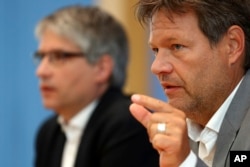 Sven Giegold, background, top candidate of the European Green Party, and Robert Habeck, chairman of the Green Party, attend a news conference after the elections for the European Parliament in Berlin, Germany, May 27, 2019.