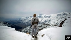 FILE - A Pakistani Army soldier with the 20th Lancers Armored Regiment stands atop the 8000-foot mountain during a patrol near his outpost, Kalpani Base, in Pakistan's Dir province on the Pakistan-Afghan border.