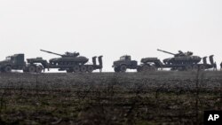 FILE - Ukrainian tanks are transported towards Ukraine's eastern Luhansk region, Dec. 12, 2021.