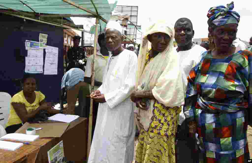 People queue to cast their votes at a polling station in the city of Ibadan, Nigeria, Saturday, April 2, 2011, before an announcement to postpone the election. Nigeria postponed its National Assembly elections Saturday as ballots and tally sheets remain