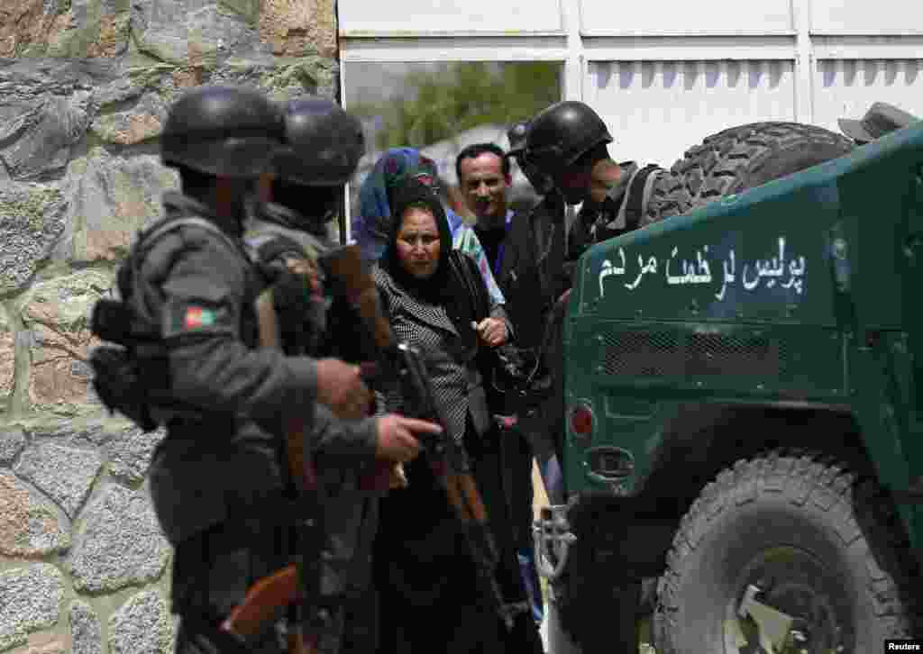 Women leave the Cure Hospital after an attack killed three Americans, Kabul, April 24, 2014.