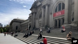 Virus Outbreak New YorOrang-orang duduk di luar Metropolitan Museum of Art pada Sabtu, 2 Mei 2020 di New York. (Foto: AP)