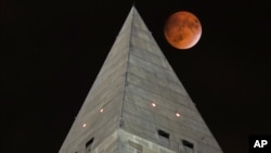 The moon passes behind the peak of the Washington Monument during a lunar eclipse, Sept. 27, 2015. Soon visitors will be able to enjoy the view from the top thanks to philanthropist David Rubenstein, who has pledged the funding needed to fix the monument's elevator, which was forced to shut its doors due to the elevator's mechanical failures. 