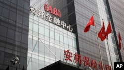 A worker cleans windows of the Anbang Insurance Group's building in Beijing, Wednesday, March 16, 2016. In a competition with Marriott International to acquire the iconic Starwood Hotels and Resorts for nearly $14 billion, Anbang upped its offer on Monday , leaving the market waiting anxiously for Marriott’s next move.