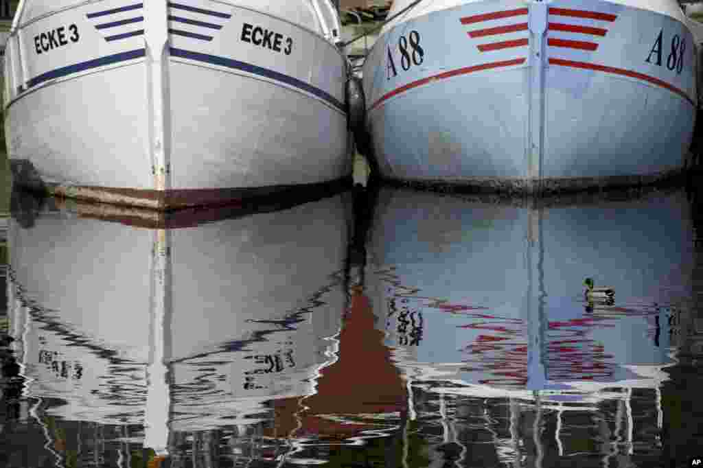 Fishing boats are reflected in the harbor in Eckernfoerde, at the Baltic Sea, Germany. Weather forecasts predict sunny weather in most parts of Germany over the weekend.