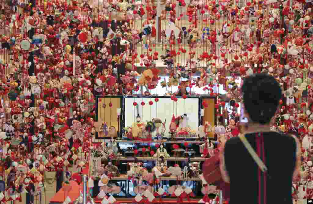 A woman looks at Hina dolls and thousands of hanging decorations marking Girls&#39; Day at a hotel in Tokyo, Japan. March 3 is celebrated as Girls&#39; Day to pray for the growth of girls in the family.