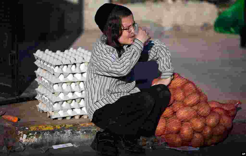 An ultra-Orthodox Jewish youth waits near food which was donated for Passover in Jerusalem. (Reuters)
