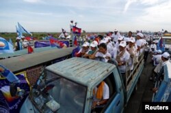 FILE - Supporters of the Cambodian People's Party stand on a truck as they are surrounded by supporters of the Cambodia National Rescue Party during a local election campaign in Phnom Penh, May 20, 2017.