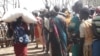 A South Sudanese woman walks away with a large bag of maize that she received in exchange for working in a drought-hit area of Northern Bahr el Ghazal. The project, called "Food for Assets", is run by international NGO, Mercy Corps.