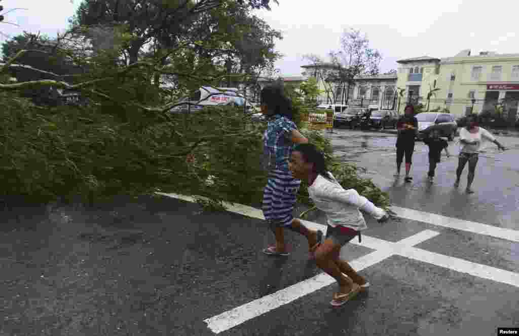 Residents rush to safety past a fallen tree during strong winds brought by Typhoon Haiyan that hit Cebu city, central Philippines, Nov. 8, 2013. 