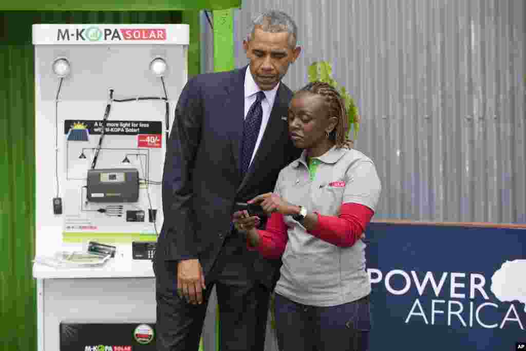 صدر براک اوباما نے پاور افریقہ انوویشن میلے کے دوران موبائل ادائیگی کے سٹال کو دیکھ رہے ہیں۔ &nbsp;
