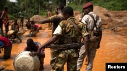 Les anciens soldats Séléka surveillent des prospecteurs d'or dans la mine à ciel ouvert de Ndassima près de Djoubissi, République centrafricaine, 9 mai 2014. 