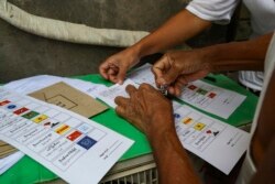 Seorang pria lanjut usia melakukan pemungutan suara lebih awal untuk pemilihan umum 8 November mendatang di kediamannya di pinggiran Yangon, Myanmar Kamis, 29 Oktober 2020. (Foto: AP)