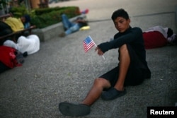 Norlan, 18, a migrant from Honduras en route to the United States, rests in a public square as he waits to regroup with more migrants, in Tecun Uman, Mexico, Oct. 26, 2018.