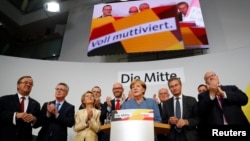德国总理默克尔在柏林德国大选第一个出口民调结果公布后的反应。（2017年9月24日）