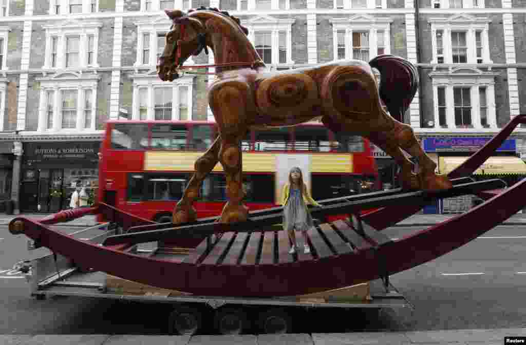 Riva Lemanski, 6 poses on a giant two-story rocking horse outside Christie&#39;s auction house in London, England.