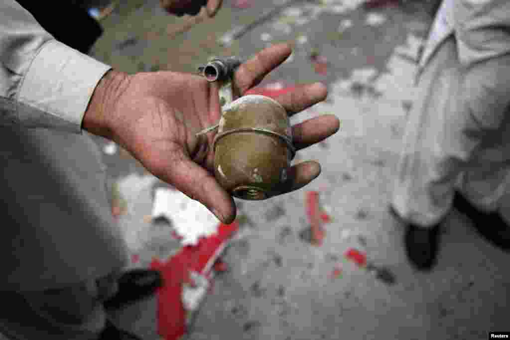 A security official shows a grenade found at the site of a bomb attack in Quetta, Pakistan, April 24, 2013.