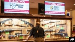 Seorang pria mengamati berbagai jenis senjata api yang dipajang di aula Indianapolis Convention Center, 25 April 2019. (Foto: dok).