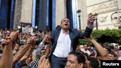 FILE - Journalists carry Yehia Kalash, head of the Egyptian press syndicate, during a protest against restrictions on the press and to demand the release of detained journalists, in front of the Press Syndicate in Cairo, Egypt May 4, 2016.