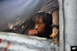 A girl watches as authorities arrive to evacuate people from her house in Tabarre, Haiti, Oct. 3, 2016.