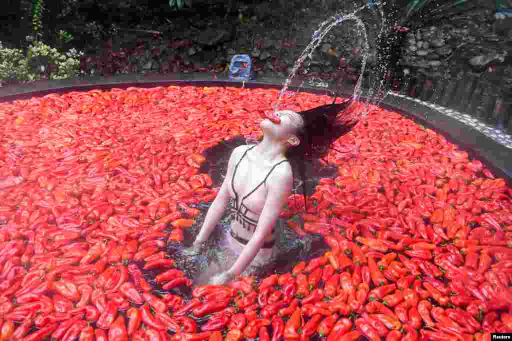 Seorang peserta, berendam di air yang penuh cabe merah, ambil bagian dalam lomba makan cabai di pemandian air panas di Yichun, Jiangxi, China.