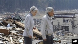 Japanese Emperor Akihito and Empress Michiko look at the tsunami-hit devastated area from the playground of Isatomae Elementary School in Minamisanriku, Miyagi Prefecture, northern Japan, April 27, 2011