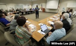 In this, Wednesday, Feb. 12, 2020 photo, Vincent Keeys, standing, president of the NAACP in Collier County, talks to a group of nonprofit leaders and government agencies about the Census undercount in 2010, in Immokalee, Florida.