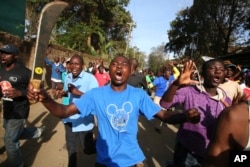 Opposition supporters, one holding a machete, take to the street in the Kawangware area of Nairobi, Kenya, Oct. 28, 2017.