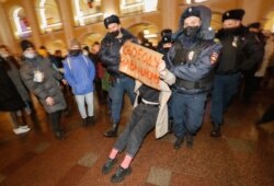 Police detain a protester with a placard reading 'Freedom for Navalny' at a demonstration in support of Russian opposition leader and anti-corruption activist Alexei Navalny in St.Petersburg, Russia, on 18 January 2021.