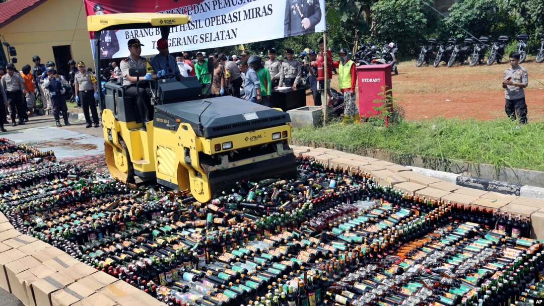 Polisi menggunakan buldozer untuk menghancurkan botol-botol alkohol ilegal yang disita di Serpong, pinggiran Jakarta, 13 April 2018. (Foto: dok).