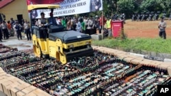 Polisi menggunakan buldozer untuk menghancurkan botol-botol alkohol ilegal yang disita di Serpong, pinggiran Jakarta, 13 April 2018. (Foto: dok).