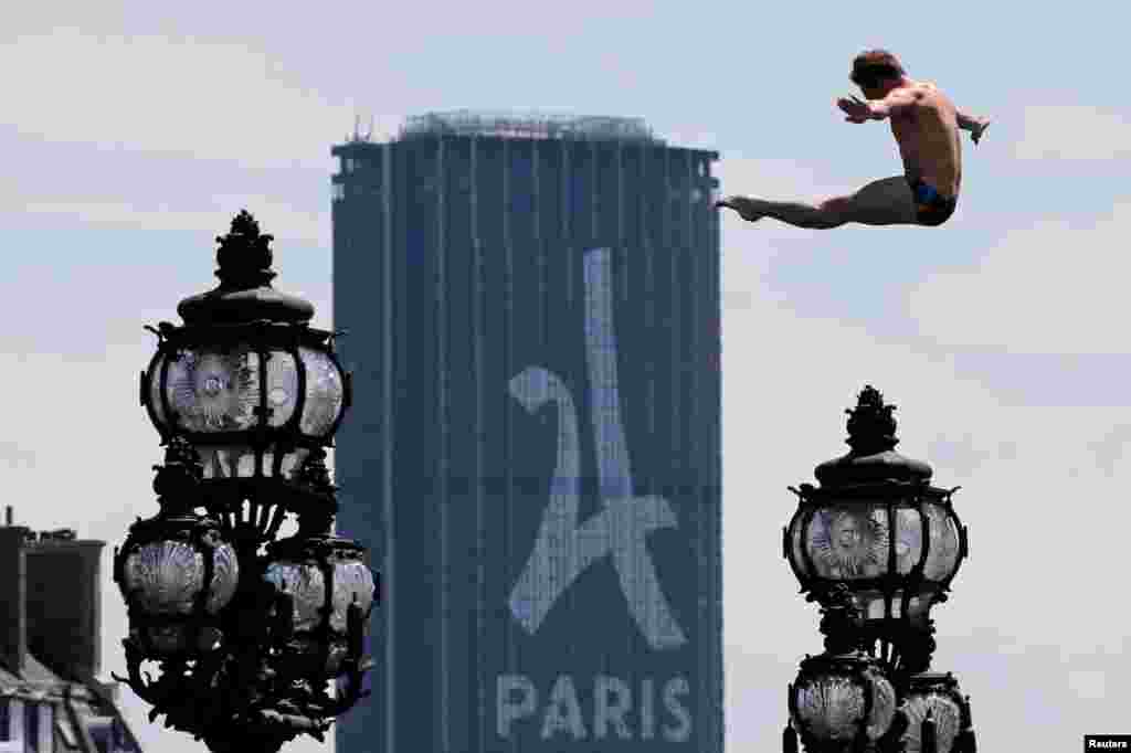 A diver jumps into the River Seine with the Montparnasse tower in the background in Paris, as the city transforms into a giant Olympic park to celebrate International Olympic Days. A variety of sporting events are being held across the city as the city bids to host the 2024 Olympic and Paralympic Games.