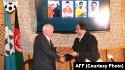 کرام الدین کریم، رئیس فعلی فدراسیون فوتبال افغانستان حین تسلیم دهی قرار داد رسمی به آقای فیستر.