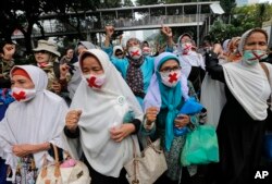 Para pendukung capres Prabowo Subanto mengenakan masker dalam unjuk rasa dekat gedung Mahkamah Konstitusi di Jakarta, Jumat, 14 Juni 2019. (Foto: AP)