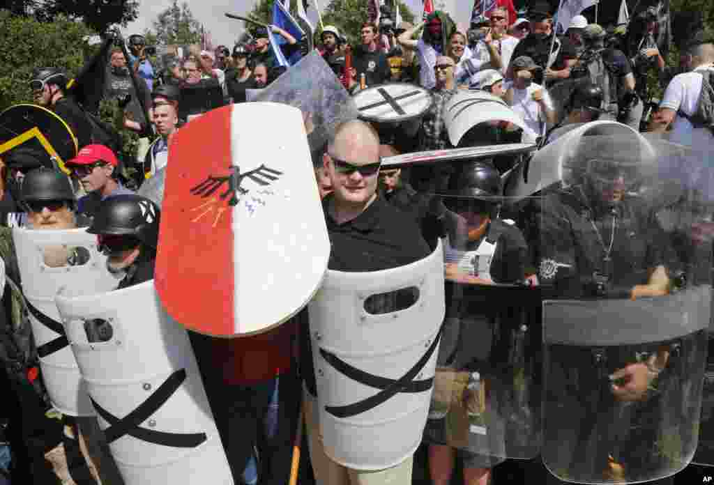 White nationalist demonstrators use shields as they guard the entrance to Lee Park in Charlottesville, Aug. 12, 2017.