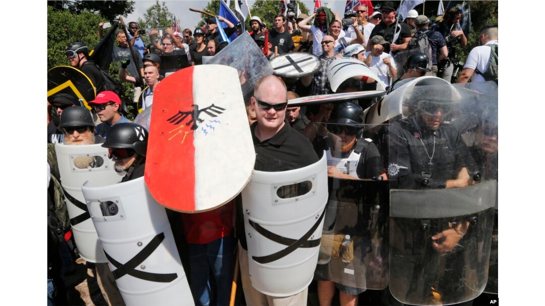 White nationalist demonstrators use shields as they guard the entrance to Lee Park in Charlottesville, Va., Aug. 12, 2017.
