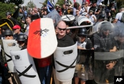 FILE - White nationalist demonstrators use shields as they guard the entrance to Lee Park in Charlottesville, Va., Aug. 12, 2017.