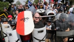 White nationalist demonstrators use shields as they guard the entrance to Lee Park in Charlottesville, Va., Aug. 12, 2017. 